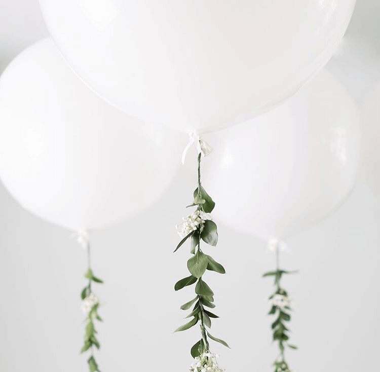 big round white balloons with green organic-style garland .