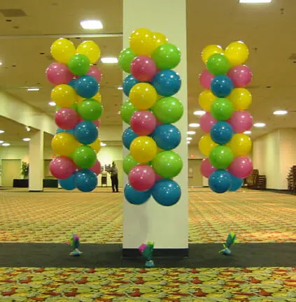 : A column of mixed color neon balloons in blue, pink, green, and yellow floating in the air.