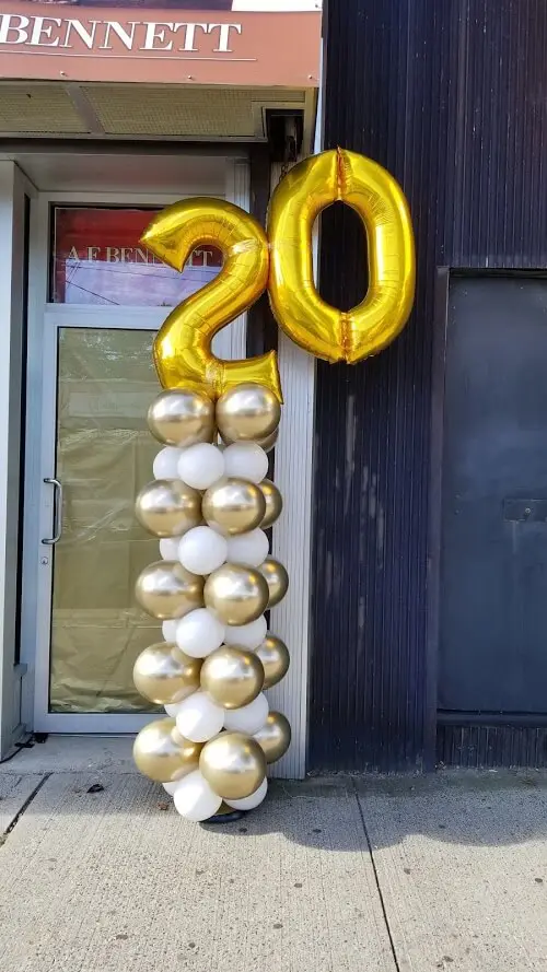 White, rose gold, and gold 20th-anniversary balloon column from Balloons Lane Balloon in NYC.