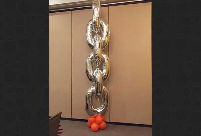Silver and orange link chain balloons column with mini balloons column for Anniversary celebration.