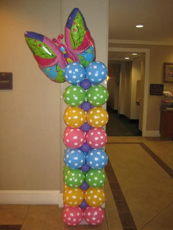 Colorful polka dot balloons with butterfly decoration in a column