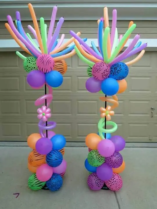 Pink, purple, orange, dark blue, lavender, wintergreen, and neon balloons in a column arrangement for a birthday party.
