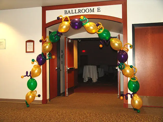 A beautiful arch made of Gold, Green, and Purple single balloons, perfect for decorating the entrance of any party room in New Jersey.