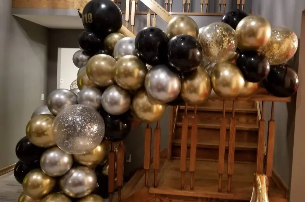 Gold, silver, and black arch decorations with silver and gold confetti balloons by Balloons Lane in NJ.