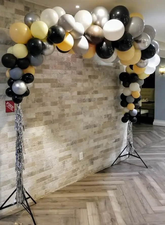 Gray, black, and silver balloons in an arch for a party celebration by Balloons Lane in NYC