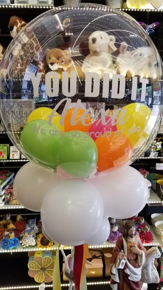 Green, yellow, orange, pink, and white personalized, balloons
