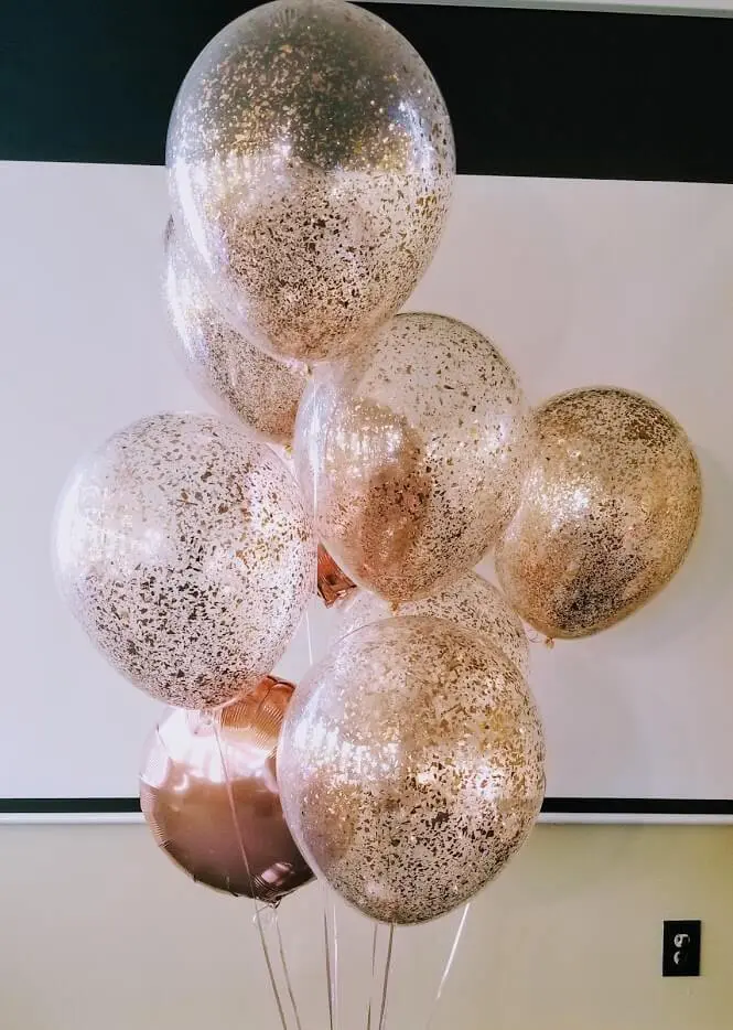 Balloons Lane in Brooklyn offers clear balloons filled with rose gold confetti, along with rose gold Mylar balloons for an anniversary party.