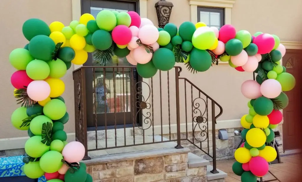 A colorful balloon arch featuring jewel lime, pink, yellow, wild berry, and green balloons arranged for decoration in Brooklyn.