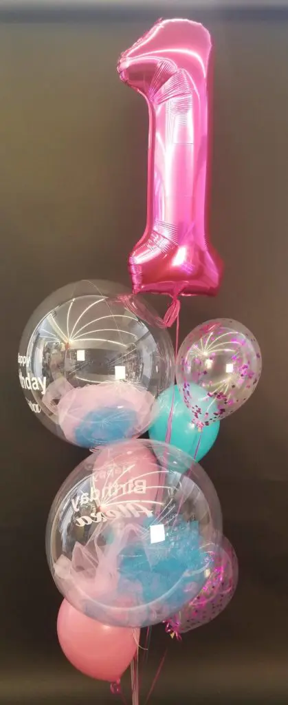 A beautiful balloon column in pink, azure, and light pink colors, featuring pink number balloons 1, created by Balloons Lane in New Jersey for a first birthday celebration.