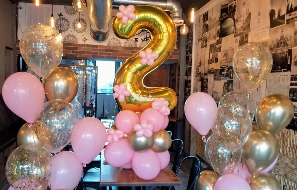 A beautiful balloon bouquet in pink, silver, and gold colors, featuring gold number balloons 2, created by Balloons Lane in Brooklyn for a second birthday balloon decoration.