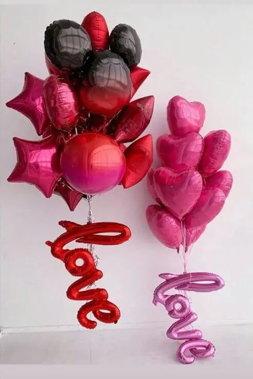 A bouquet of Valentine's Day mylar balloons in pink chrome, red, black and chrome black colors, featuring script text that spells Love