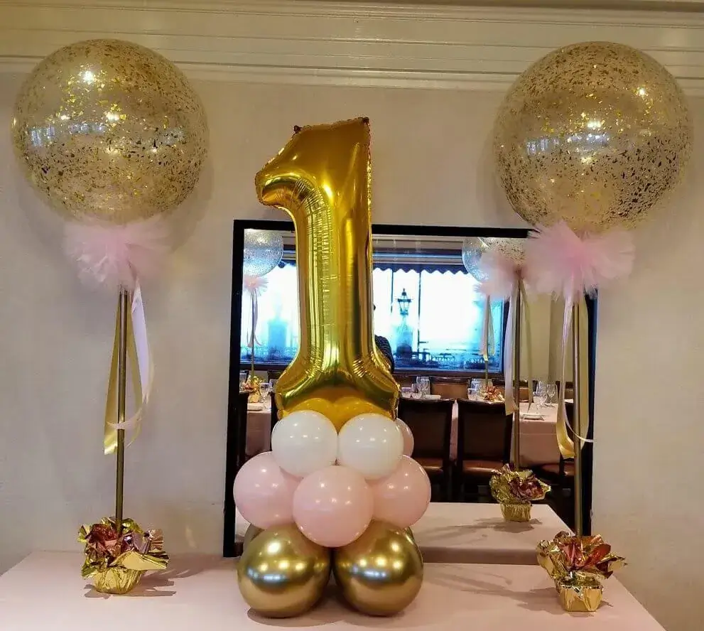 An eye-catching balloon arrangement in white, pink, and gold, including a large gold number 1 balloon, created by Balloons Lane for a first birthday celebration in Staten Island.